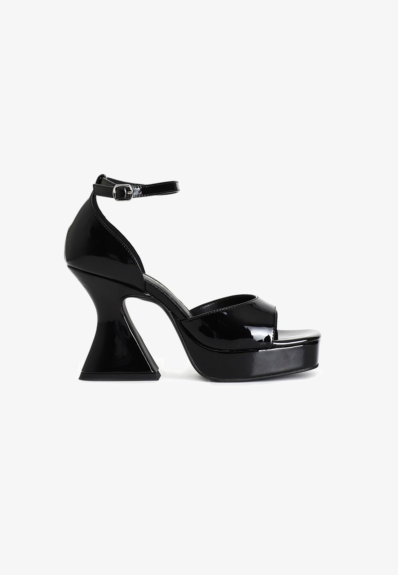 Black patent leather platform sandals featuring a peep-toe design, ankle strap with buckle, and a distinctive flared heel.
