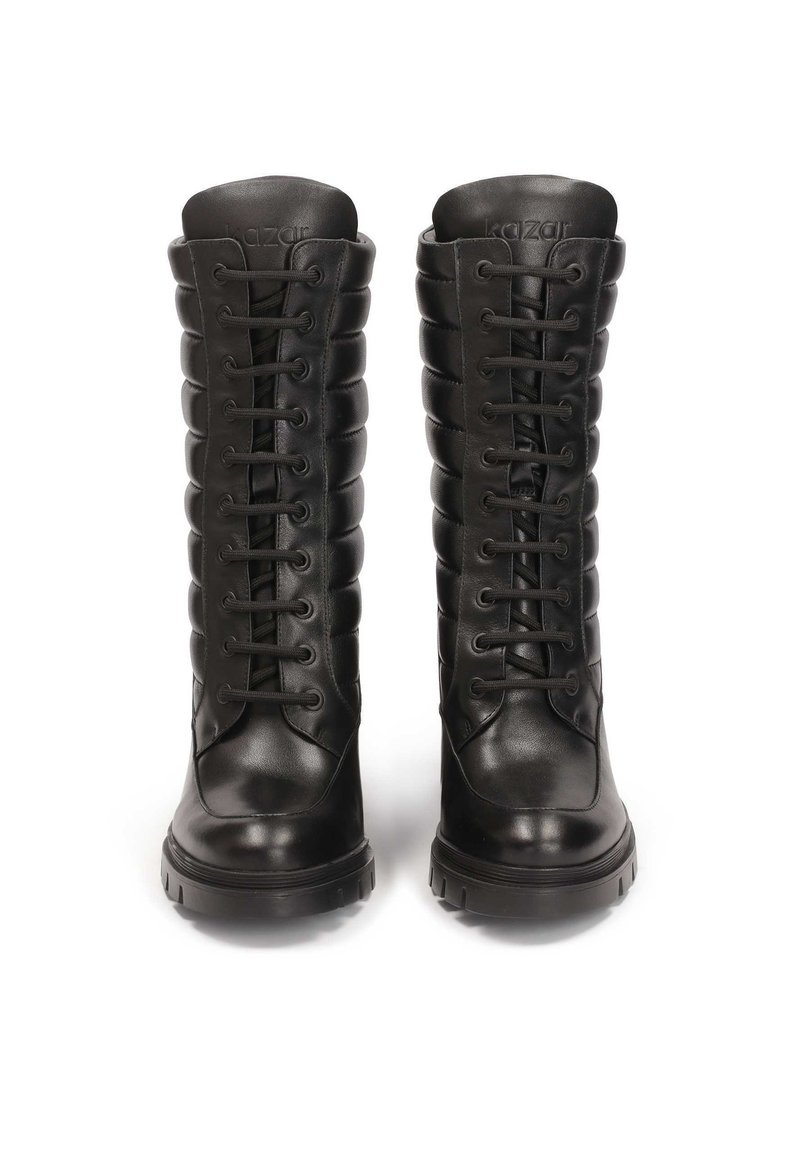 Botas de cuero negras hasta la rodilla con un diseño acolchado, puntera redonda y detalles de cordones. Suela de goma gruesa para durabilidad y tracción.