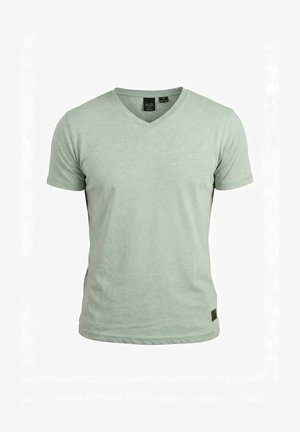 Maglietta da uomo verde chiaro a maniche corte con scollo a V e una piccola etichetta nera vicino all'orlo, mostrata su uno sfondo bianco.