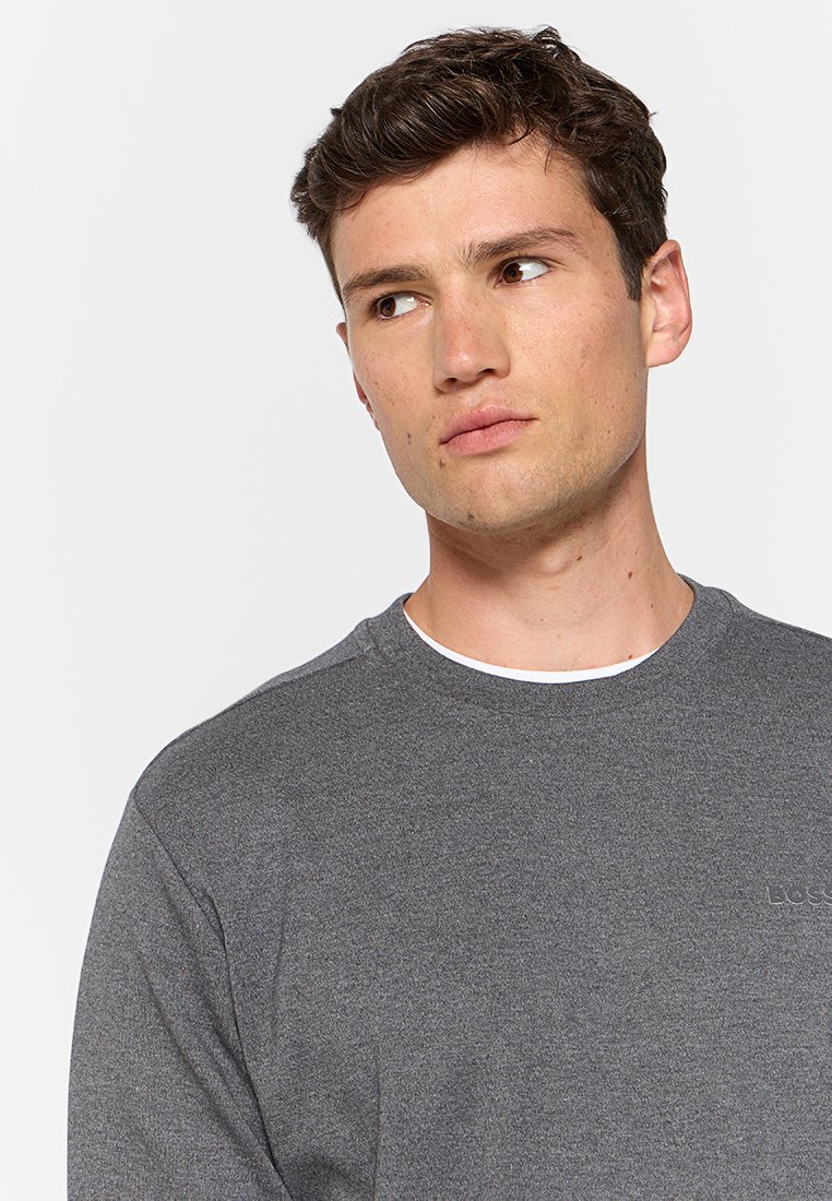 Sudadera gris de cuello redondo con un acabado texturizado y acentos de color blanco en el cuello. Presenta un sutil logo en el pecho.