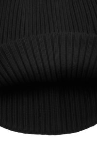 Zwarte gebreide stof met een verticaal ribbelpatroon, die een zachte textuur en afgeronde rand laat zien, wat zorgt voor een gezellige, warme uitstraling.
