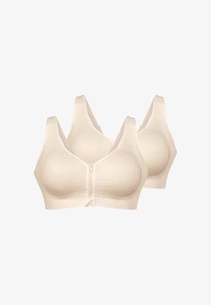 Due reggiseni beige senza cuciture con chiusure lampo frontali e spalline larghe, mostrati su uno sfondo bianco semplice.