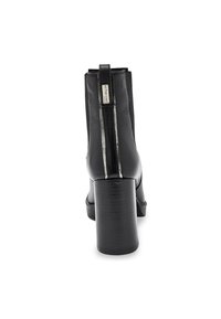 Botín negro de cuero hasta el tobillo con un tacón grueso, cremallera trasera y un sutil acento metálico a lo largo de la costura. Textura suave y diseño elegante.