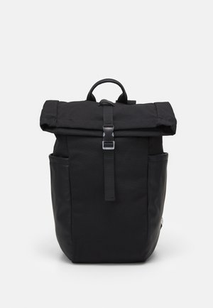 Zwarte rugzak met roll-top ontwerp, gemaakt van stof en lederen accenten, voorzien van een sluiting met riem aan de voorkant en zijzakken.