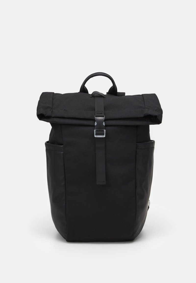 Sac à dos noir avec un design à rabat enroulable, fabriqué en tissu avec des accents en cuir, doté d'une fermeture à sangle frontale et de poches latérales.