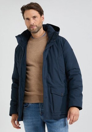 Marineblauwe hoodie met een ritssluiting en knoopsluiting, met voorzakken, een getextureerde bruine trui eronder en een ontspannen pasvorm.