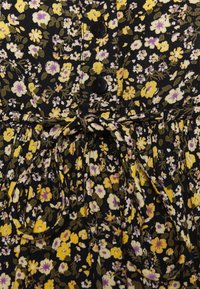 Vestido de tecido preto com um pequeno padrão floral amarelo e roxo, apresentando botões na parte da frente e um detalhe na cintura com laço. Textura suave, design casual.