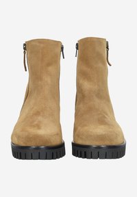 Pair of tan suede ankle boots with black chunky rubber soles and side zippers, shown from the front.