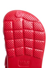 Red rubber shoe sole with a patterned surface featuring squares and circles, and a logo embossed at the bottom center.