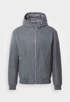Chaqueta con capucha gris que cuenta con un cierre frontal con cremallera, puños y dobladillo acanalados, y dos bolsillos laterales con cremalleras plateadas. Aislamiento en el forro interior.