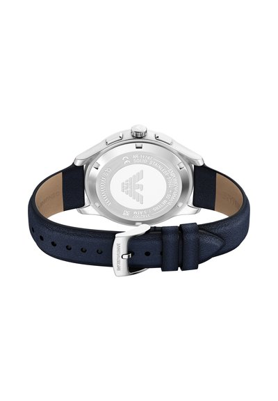 Montre en acier inoxydable argenté avec un bracelet en cuir bleu foncé, dotée d'une finition polie, d'un boîtier rond et d'un dos texturé avec des détails gravés.
