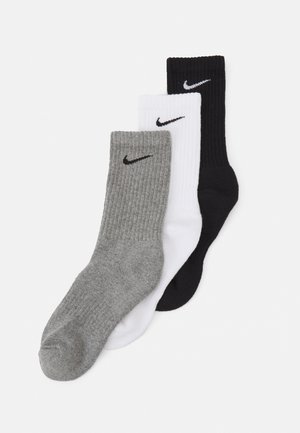 Três pares de meias Nike de cano curto em cinza, branco e preto. Todas apresentam textura canelada e um pequeno logótipo preto na bainha.