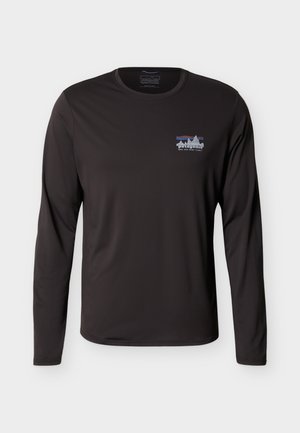 Must pikkade varrukatega Patagonia särk, millel on väike mitmevärviline mäglogo ja vasakul rinnal tekst "Save Our Home Planet".