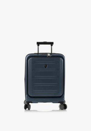 Valigia rigida da cabina di colore blu scuro con quattro ruote doppie girevoli e manico telescopico esteso.