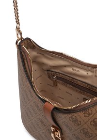 Sac à épaule brun à motifs avec quincaillerie dorée, chaîne en bandoulière, fermeture éclair, et un intérieur beige comportant une poche et un design de logo imprimé.