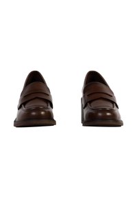 Brune læder loafers med en let hævet hæl, der har to overlappende remme fortil og en tekstureret sål.