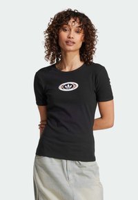Czarny prążkowany t-shirt z krótkim rękawem, z centralnym białym i brązowym okrągłym wzorem logo z trzema paskami.