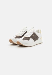 White sneakers with a textured brown panel, featuring gold accents and flat laces. The sole is light with a slight elevation.