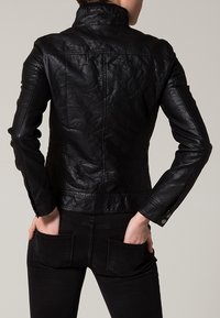 Svart läderjacka med figursydd design, hög krage och ärmslut med knappar. Texturerad yta och strukturerade sömmar på baksidan förbättrar hållbarheten.
