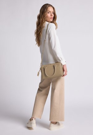 Beige Lederhandtasche mit doppelten Tragegriffen und verstellbarem Riemen. Glatte Textur, rechteckige Form, mit dezenten Nähten und einem Anhänger.