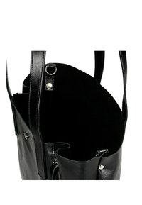 Černá kožená taška přes rameno s hladkým vnějším povrchem, otevřeným vrškem a měkkým interiérem. Obsahuje uzávěry na patentky a zip s kovovými akcenty.