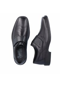 Chaussures noires en cuir avec un bout arrondi, des accents cousus et une sangle Velcro. Semelle en caoutchouc pour une meilleure adhérence. Rembourrage intérieur pour plus de confort.