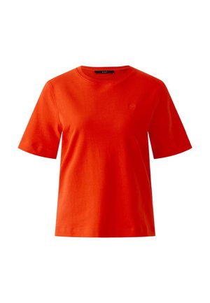 Leuchtend orangefarbenes T-Shirt mit kurzen Ärmeln und Rundhalsausschnitt, mit einem kleinen, geprägten Logo auf der linken Brustseite und einem schwarzen Etikett im Krageninneren.