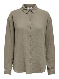 Langärmliges Hemd in Olivgrün, gefertigt aus strukturiertem Stoff mit spitzem Kragen und sieben Knöpfen vorne. Saum an den Seiten abgerundet.
