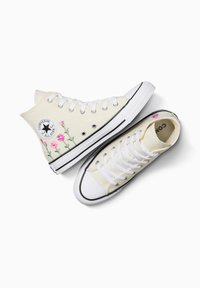 Sneakers in tela alti e bassi in crema con lacci bianchi. Caratterizzati da ricami floreali e una suola in gomma nera. Iconico logo a stella sul lato.