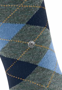 Męskie skarpetki w wzór argyle w odcieniach granatu, niebieskiego i zielonego z pomarańczowym wzorem w diament. Zawierają metalowy akcent z logo.