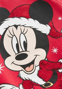 Roter Sweatshirt mit einem großen Grafikdruck eines Cartoon-Charakters in einer Weihnachtsmütze, mit glitzernden Details auf der Mütze und den Akzenten des Kostüms.