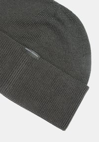 Berretto in maglia grigio con risvolto a coste, realizzato in tessuto testurizzato. Presenta un piccolo etichetta cucita con il logo "Armani Exchange".