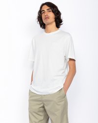 Biała bawełniana koszulka z okrągłym dekoltem i krótkimi rękawami. Posiada małe wyszywane logo na piersi oraz luźny krój.