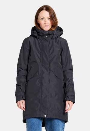 Black waterproof jacket with a high collar, large front pockets, and a hood. Smooth texture and mid-length design, featuring snap closure.