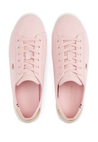 Pár světle růžových plátěných tenisek s bílými podrážkami, zlatými akcenty na patách a tkaničkách, zobrazených z horního pohledu na bílém pozadí.