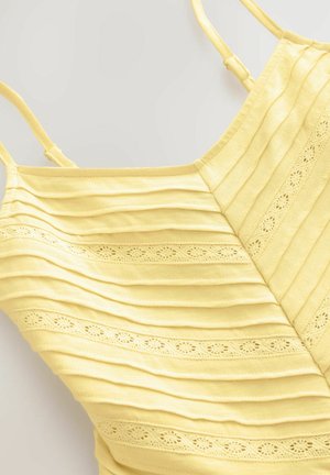 Top giallo con texture plissettata e accenti ricamati. Spalline sottili e design aderente. Tessuto morbido con una leggera lucentezza.