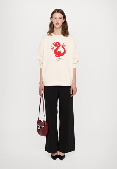 Cremfarbener Sweatshirt mit roter Grafik einer Schlange und dem Text "WEEKEND". Kombiniert mit schwarzen weit geschnittenen Hosen und einer burgunderfarbenen Umhängetasche.