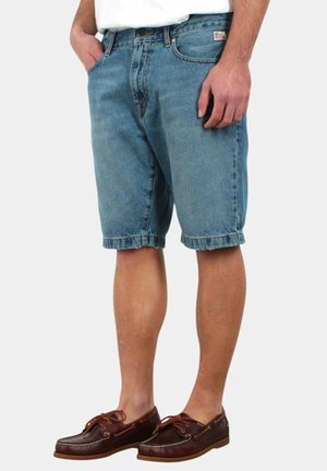 Shorts in denim blu chiaro, con una vestibilità comoda, orlo arrotolato e tasche frontali. Abbinati a scarpe da barca in pelle marrone.