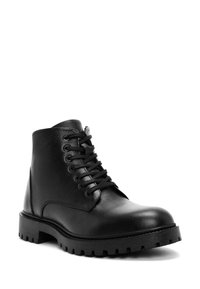 Botín negro de cuero con acabado texturizado, punta redonda, diseño con cordones y suela de goma robusta con profundos surcos para mayor tracción.