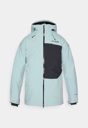 Chaqueta de color azul claro con bolsillo negro de acento, cierre de cremallera y capucha ajustable. Presenta una tela suave y resistente al agua, así como puños elásticos.