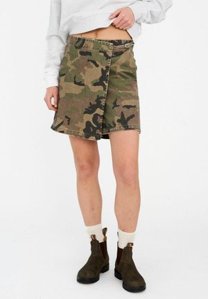 Maskáčová rifľová sukňa s zavinovacím dizajnom, snehovozelenými a hnedými vzormi, bočným zapínaním na gombíky a lemom nad kolenami.