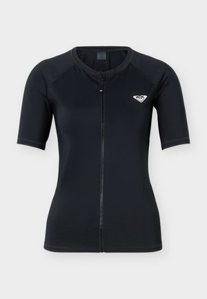 Top de costum de scafandru negru cu mâneci scurte, cu fermoar frontal și logo alb în formă de inimă pe partea stângă a pieptului, pe un fundal alb simplu.