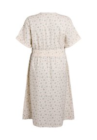 Vestido de patrón floral en color crema con mangas cortas y cintura elástica. La tela ligera presenta motivos de flores en verde y azul.