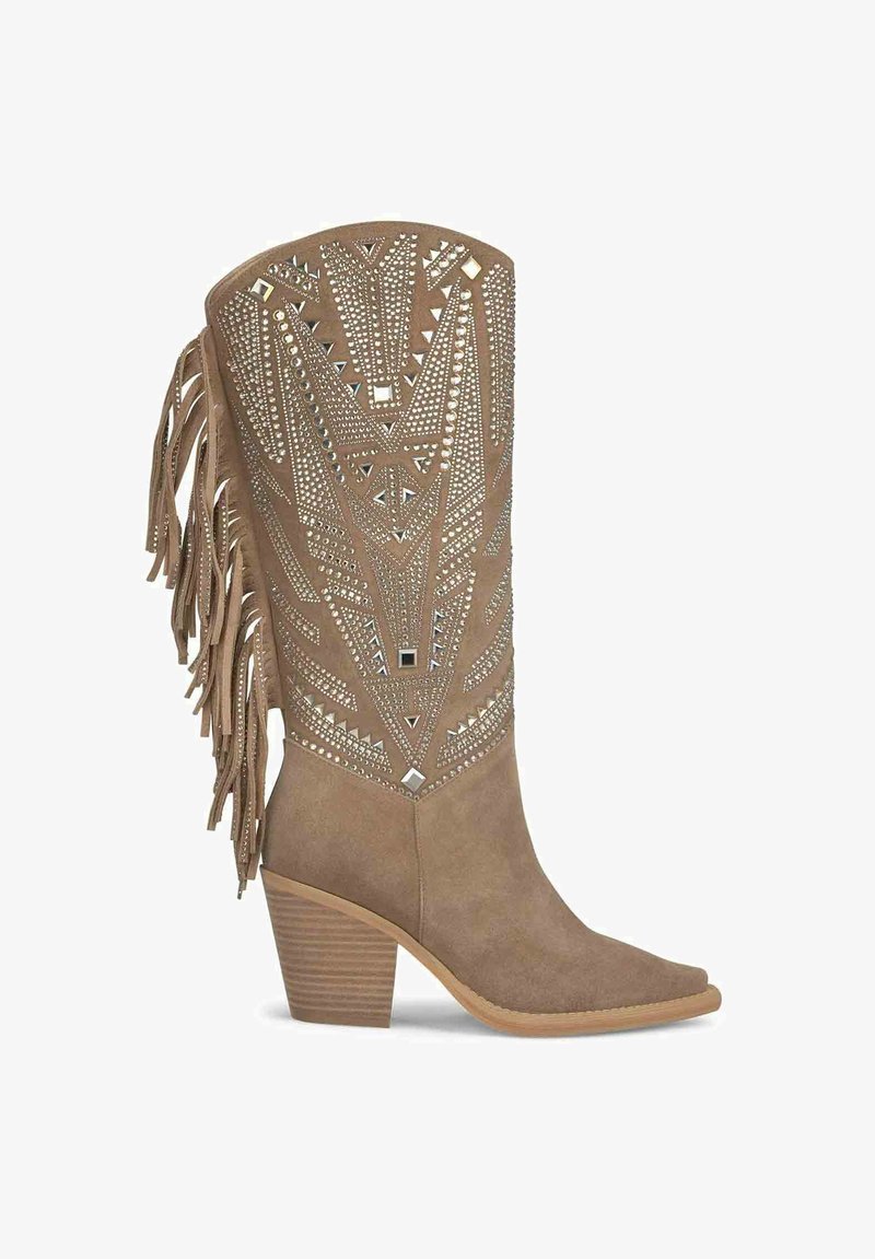Jasnobrązowy zamszowy but kowbojski z wąskim noskiem, wielowarstwowym frędzlem i geometrycznymi srebrnymi ćwiekami ozdabiającymi cholewkę.