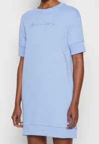 Ljust blå kortärmad klänning i mjukt tyg med en avslappnad passform, med broderad "Armani Exchange"-logotyp över bröstet.