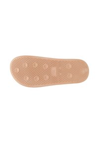 Semelle en caoutchouc de couleur beige clair avec un motif texturé de triangles et de grips circulaires pour la traction et un mouvement flexible.