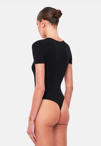 Zwarte bodysuit met korte mouwen, een gladde textuur, minimalistisch ontwerp, hoge beenopeningen en een stringrug. Eenvoudig en nauwsluitend.