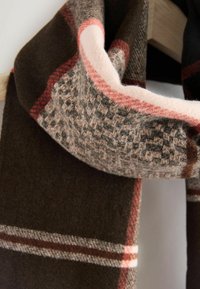 Brown and beige textile scarf featuring a textured pattern and stripes in pink and red. Soft material with a woven design.