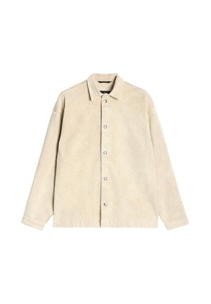 Beige manchetjakke i kordfløjl med knapper foran, spidst krave og lange ærmer. Glat tekstur og subtil glans.