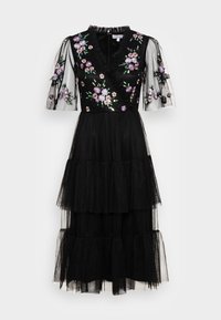 Robe noire avec broderie florale, col en V, manches courtes transparentes, jupe en tulle à volants. Présente des motifs de fleurs complexes en violet et vert.